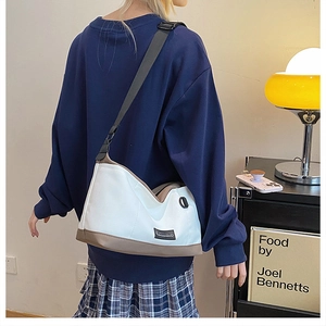 Detailed shot of canvas crossbody bag with SANRING label on a model in a home setting