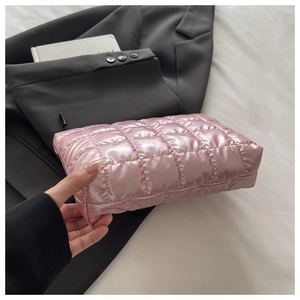 Detailed view of pink quilted satin cosmetic bag with square stitching and black zipper