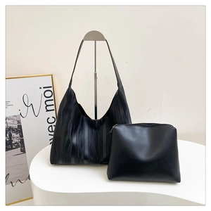 Macro detail of the black tote bag set featuring unique vertical wavy texture and sub-pouch