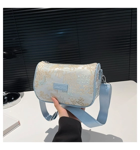Detail of light blue embroidered cylinder bag featuring classical Chinese landscape art