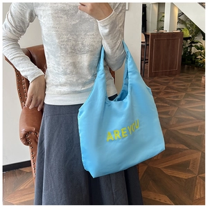 Gros plan du sac fourre-tout bleu clair en nylon avec imprimé jaune ARE YOU
