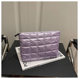 Close-up of quilted light purple makeup bag with a metallic finish and black zipper detail