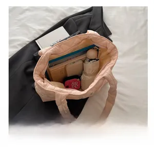 Spacious interior of light pink quilted nylon tote bag filled with daily essentials