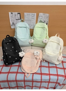 Group display of school backpacks in five pastel colors with flower embroidery and charms