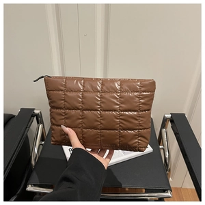Close-up of coffee brown quilted pouch with soft padded fabric and black zipper closure