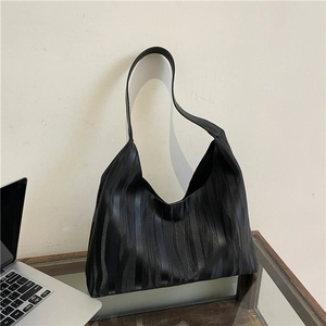 Minimalist large black tote bag with wave texture and wide strap for daily fashion use