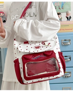 Detail view of the red and white printed canvas bag with a clear window for display