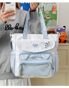 Detail of blue student tote bag showing cute cat-ear pocket with transparent window