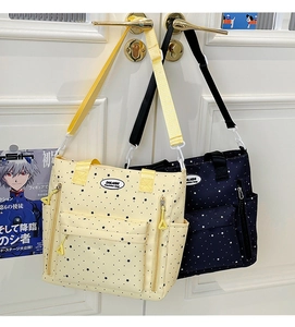 Dettaglio della borsa tote multitasche con motivo a stelle in beige e blu scuro