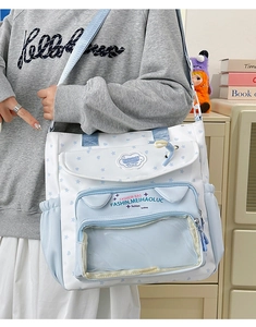 Detail of light blue star print ita bag with transparent PVC window and fashion label