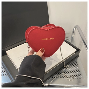 Détail du mini sac rouge en forme de cœur avec lettrage doré et chaîne argent
