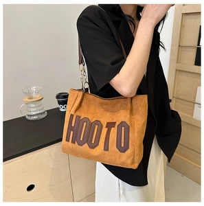 Détail du sac cabas vintage en daim gingembre avec patch HOOTO et chaîne dorée