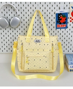 Dettaglio della borsa in tela gialla con stelle nere e tracolla gialla luminosa
