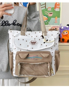 Detail view of contrast color tote bag featuring a transparent front window and star prints