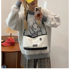 Fashionable black and white contrast canvas shoulder bag shown in a lifestyle mirror selfie