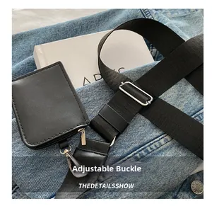 Detail showing the adjustable wide shoulder strap with silver buckle and small coin pouch
