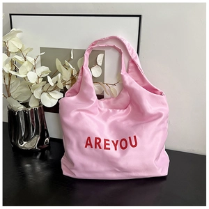 Détail du sac cabas en satin rose avec inscription AREYOU rouge et large bandoulière