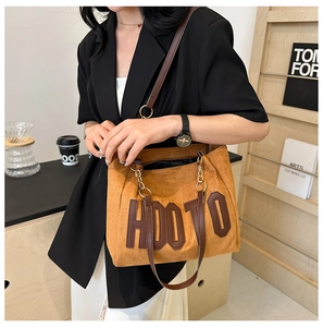 Gros plan sur le sac cabas en daim marron avec logo HDOTO et détails dorés de la chaîne
