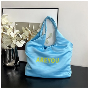 Vue détaillée du sac cabas bleu ciel avec impression de lettres AREYOU jaunes
