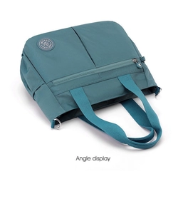 Detail of teal nylon tote bag featuring front zipper pocket and sturdy top handles
