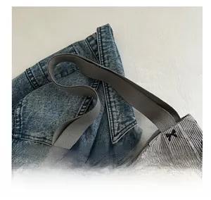 Dettaglio della borsa tote in velluto grigio con ricamo di fiocco nero e motivo a rombi