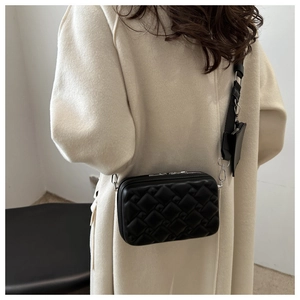 Detail of black woven crossbody bag with wide shoulder strap and mini coin pouch