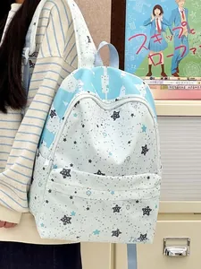 Detail view of large star print backpack worn by person in a cozy room setting