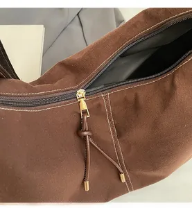 Gros plan sur la fermeture éclair dorée et la texture marron d'un sac cabas vintage