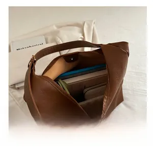 Interior view showing the large capacity of the brown hobo bag with daily essentials