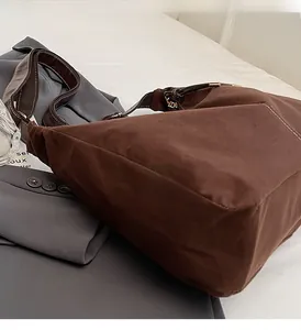 Détail du sac cabas vintage marron avec surpiqûres contrastées blanches sur tissu