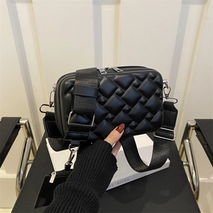 Quilted black crossbody bag with wide strap and small coin purse in modern minimalist style