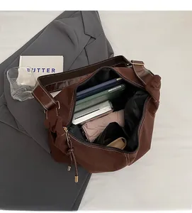 Détail de l'intérieur spacieux d'un grand sac fourre-tout en toile marron avec accessoires