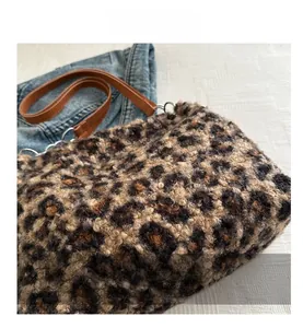 Detalle de bolso de peluche de leopardo con correa de cuero y aro metálico