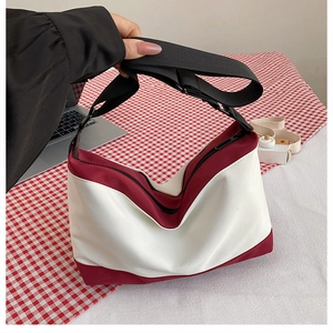 Top view of two-tone canvas crossbody bag with red trim and wide nylon strap