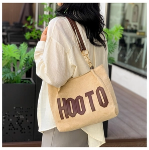 Détail du sac cabas kaki avec logo HOOTO, bandoulière cuir et chaîne dorée