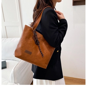Detail view of retro brown tote bag featuring leather texture and fashion patch accent