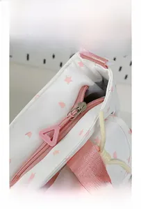 Detail of smooth pink resin zipper and star pattern fabric on the large student handbag