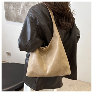 Detailed back view of a beige minimalist tote bag with elegant pleated texture and stitching