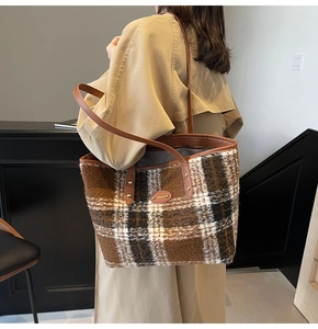 Dettaglio della borsa tote in lana a quadri con manici in pelle marrone e logo