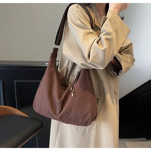 Détail du grand sac hobo marron vintage avec coutures contrastées et bandoulière réglable