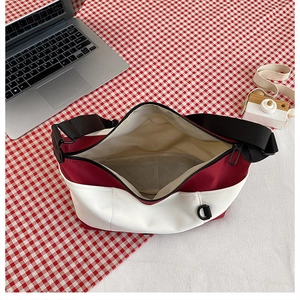 Top view of red and white canvas crossbody bag showing spacious interior and zipper