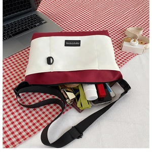 Interior view of the red and white canvas crossbody bag showing storage for phone and makeup