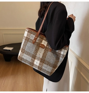 Dettaglio della borsa tote in tweed con motivo scozzese marrone e tracolla in pelle