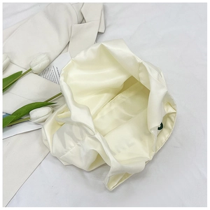Vue de dessus de l'intérieur spacieux en satin de ce sac cabas crème élégant