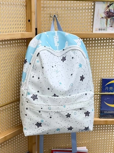 Detailed side view of star-patterned canvas backpack with a mesh side water bottle pocket