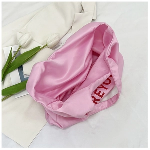 Détail du sac cabas en satin rose avec le logo REYOU rouge imprimé à l'intérieur