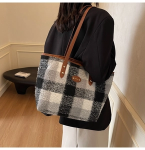 Dettaglio della borsa tote grande in lana a quadri con tracolla in pelle marrone su modella