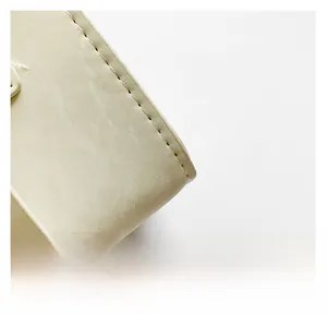 Detailed close-up showing the premium cream leather texture and uniform stitching on the bag