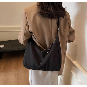 Détail du sac Hobo noir avec surpiqûres blanches et bandoulière large réglable