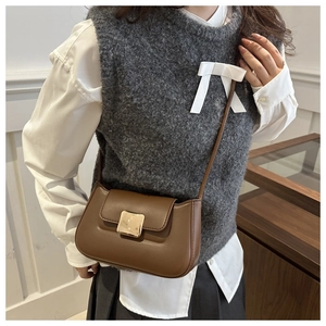 Detailed view of a brown vintage crossbody bag featuring a square metal lock and flap